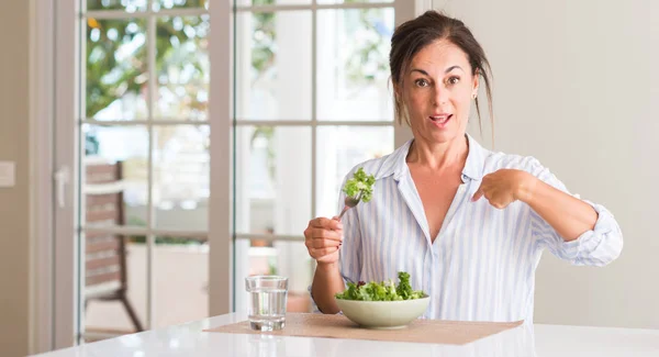 中年女性自宅自分自身に驚き顔人差し指をボウルにサラダを食べる — ストック写真