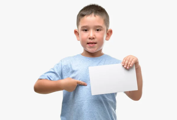 Criança Cabelos Escuros Segurando Cartão Branco Com Rosto Surpresa Apontando — Fotografia de Stock