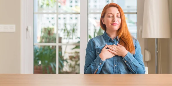 Redhead Woman Home Smiling Hands Chest Closed Eyes Grateful Gesture — Stock Photo, Image