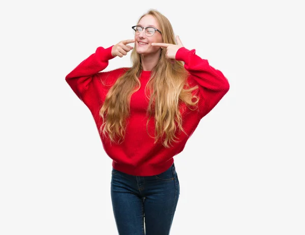 Die Blonde Teenagerin Roten Pullover Lächelt Selbstbewusst Und Zeigt Mit — Stockfoto