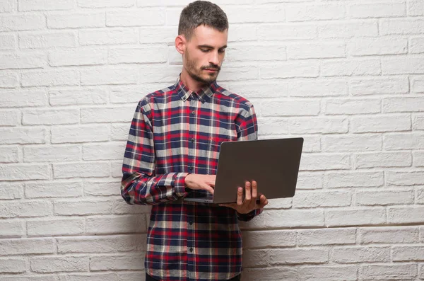 Молодий Дорослий Чоловік Над Цегляною Стіною Використовує Ноутбук Впевненим Виразом — стокове фото
