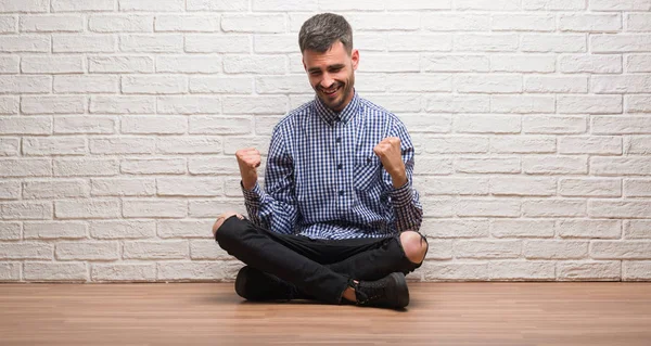 Hombre Adulto Joven Sentado Sobre Pared Ladrillo Blanco Muy Feliz — Foto de Stock