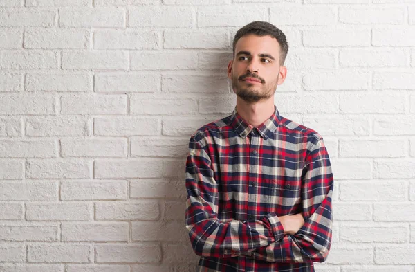 Homem Adulto Jovem Sobre Parede Tijolo Branco Sorrindo Lado Olhando — Fotografia de Stock