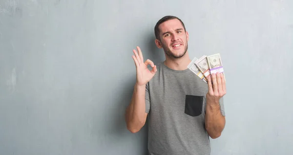Young Caucasian Man Grey Grunge Wall Holding Bunch Money Doing — Stock Photo, Image