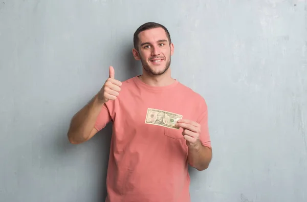 Joven Caucásico Hombre Sobre Gris Grunge Pared Mostrando Diez Dólares —  Fotos de Stock