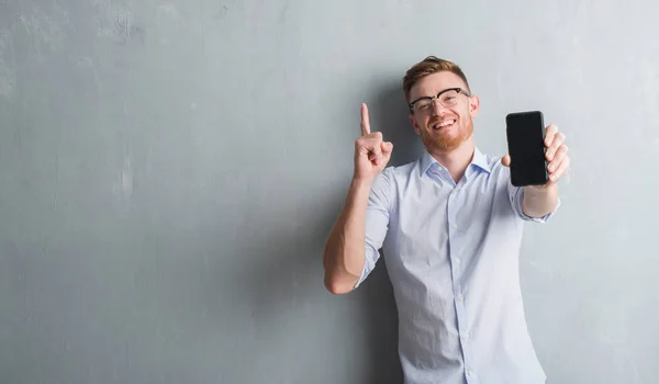Genç Kızıl Saçlı Adam Akıllı Telefon Boş Ekran Gösterilen Gri — Stok fotoğraf