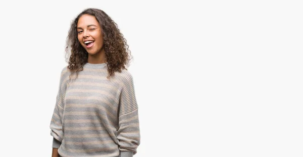 Beautiful young hispanic woman wearing stripes sweater winking looking at the camera with sexy expression, cheerful and happy face. — Stock Image Beautiful Young Hispanic Woman Wearing Stripes Sweater Winking Looking Camera Royalty Free Stock Photos