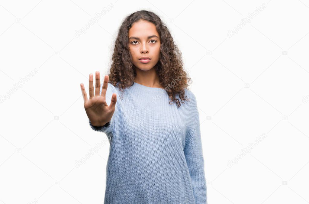 Beautiful young hispanic woman with open hand doing stop sign with serious and confident expression, defense gesture