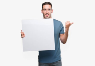 El ve parmak ile yukarı dönük mutlu yüz gülümseyen ile reklam afişi tutan yakışıklı genç