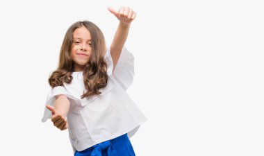 Esmer Latin kız el ile pozitif jest yapıyor onaylama başparmak gülümseyen ve başarı için mutlu. Kamera, kazanan jest arıyorsunuz.