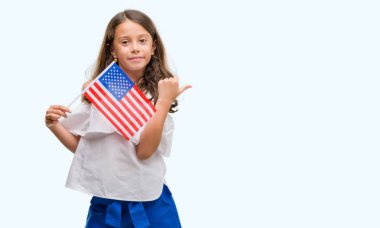 İşaret ve başparmak kadar mutlu yüz gülümseyen tarafı ile gösterilen Amerika Birleşik Devletleri bayrağı tutarak esmer Latin kız