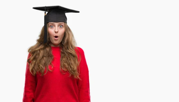 Young Blonde Woman Wearing Graduation Cap Scared Shock Surprise Face — Stock Photo, Image