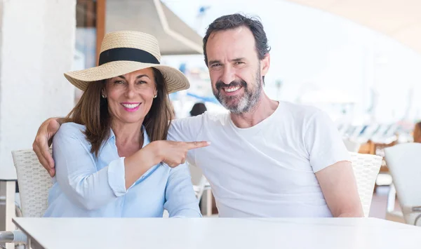 Pareja Mediana Edad Sentada Terraza Muy Feliz Señalando Con Mano —  Fotos de Stock