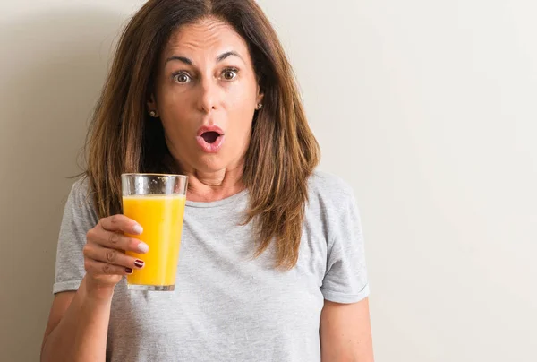 Middle Age Woman Drinking Orange Juice Glass Scared Shock Surprise — Stock Photo, Image