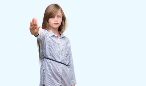 ブルーのシャツを身に着けている若いブロンド幼児が防衛ジェスチャー 深刻な自信を持って式に一時停止の標識をやって手を開いてください — ストック写真