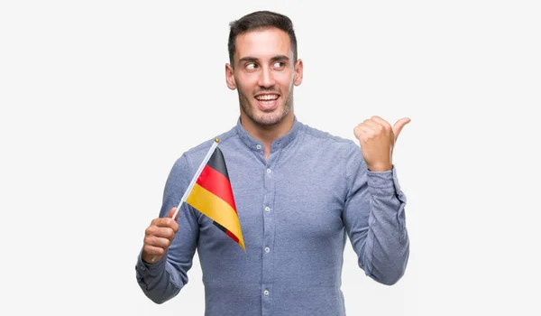 Przystojny Młody Mężczyzna Trzyma Flagę Niemiec Skierowana Dłoni Palców Górę — Zdjęcie stockowe