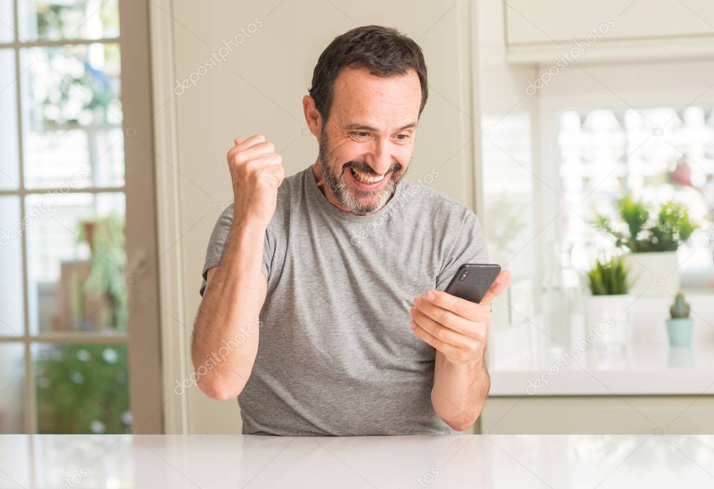 Middle age man using smartphone screaming proud and celebrating victory and success very excited, cheering emotion