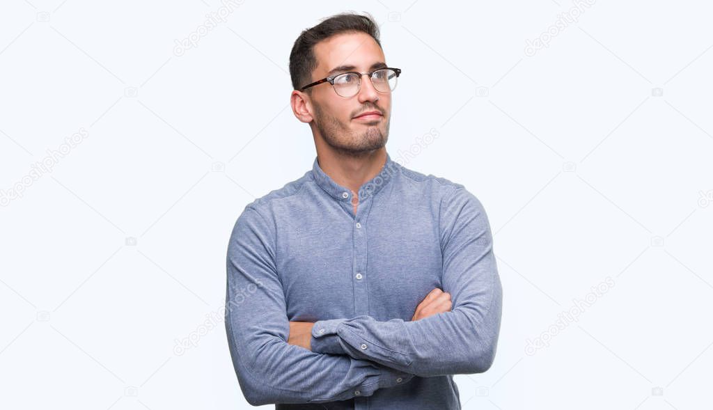 Handsome young elegant man wearing glasses smiling looking side and staring away thinking.