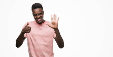 Gösterilen ve parmakları ile işaret pembe t-shirt giyen genç Afro-Amerikan adam kendinden emin ve mutlu gülümseyerek süre 6 numara.