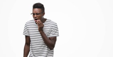 Genç Afro-Amerikan adam gözlük ve Donanma tişört dokunmadan diş ağrısı veya dişlerde dişlerle ilgili hastalık nedeniyle acı ifadesi ile el ile ağız. Diş hekimi kavramı.