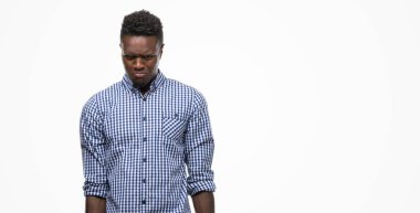 Mavi gömlek giymiş genç Afro-Amerikan adam depresif ve kızgın ve korkmuş ağlıyor sıkıntı için endişeleniyorum. Üzgün ifade.