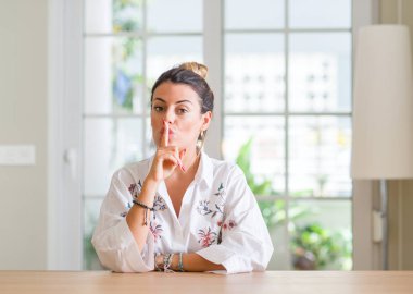 Genç kadın evde dudaklarında parmak ile sessiz olmanı. Sessizlik ve gizli kavramı.