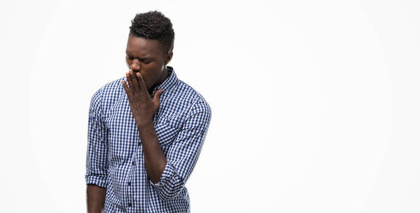 Young african american man wearing blue shirt bored yawning tired covering mouth with hand. Restless and sleepiness.