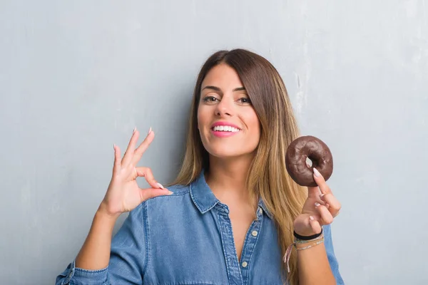 Ung Vuxen Kvinna Över Grå Grunge Vägg Äta Choklad Donut — Stockfoto