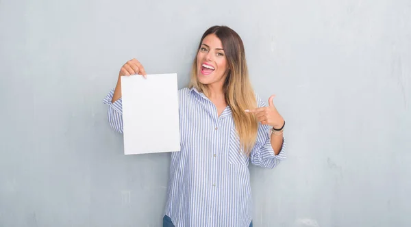 Young Adult Woman Grey Grunge Wall Holding Blank Paper Sheet — Stock Photo, Image