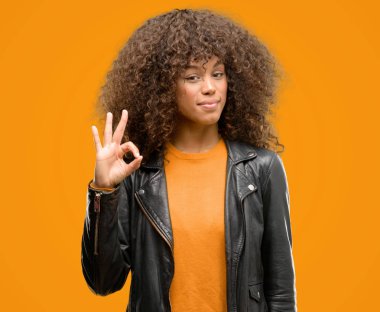 Afrikalı-Amerikalı kadın parmakları, mükemmel sembolü olan ok işareti yapıyor bir deri ceket