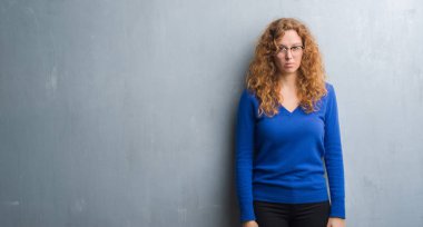 Gri grunge duvar şüpheci ve sinir, papatyanın üzgün sorun nedeniyle genç Kızıl saçlı kadın. Negatif kişi.