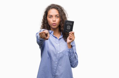 Genç İspanyol kadın holding pasaport, İtalya ile kamera ve size parmakla, el işareti, pozitif ve kendinden emin bir jest ön