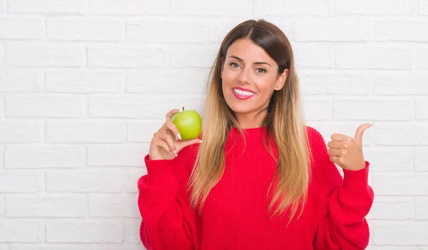 Junge Erwachsene Frau Über Weißer Backsteinmauer Isst Frischen Grünen Apfel — Stockfoto