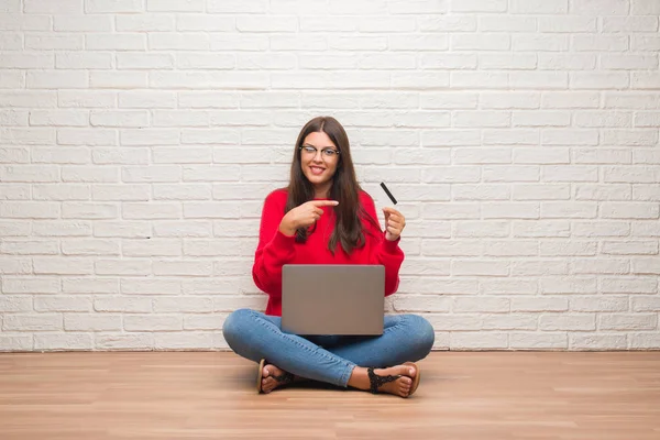 Young Brunette Woman Sitting Floor White Brick Wall Paying Holding - Stock-foto