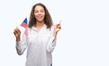 Estates Amerika bayrağı çok mutlu el ve parmak ile tarafına işaret tutan genç İspanyol kadın