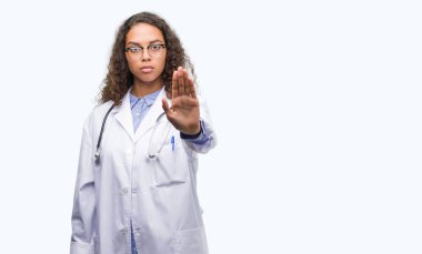 Genç İspanyol doktor kadın açık eliyle dur işareti ile ciddi ve kendine güvenen ifade, savunma hareketi yapıyor