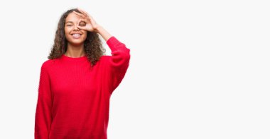 Gülümseyen, parmakları ile mutlu yüz üzerinden seyir göz el ile ok jest yapıyor kırmızı kazak giyen genç İspanyol kadın.