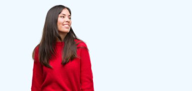 Kırmızı kazaklı uzak tarafına gülümseme ile yüzünde, doğal ifade arıyorum giyen genç güzel İspanyol. Kendine güvenen gülüyor.