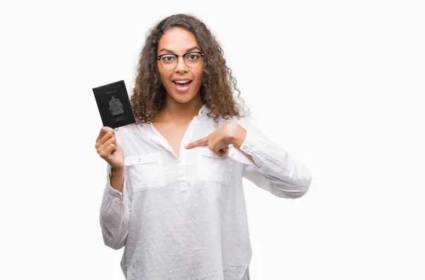 Young Hispanic Woman Holding Passport Canada Surprise Face Pointing Finger — Stock Photo, Image