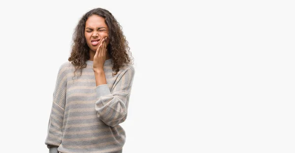 美しい若いヒスパニック系女性の歯痛や歯の歯科病気のため痛みを伴う式で手で口に触れるストライプ セーターを着ています 歯医者コンセプト — ストック写真