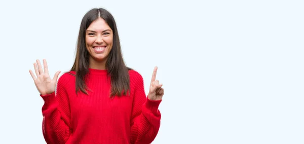 指で上向きの表示と赤いセーターを着ている若い美しいヒスパニック系ナンバー 自信を持って 幸せな笑みを浮かべて — ストック写真
