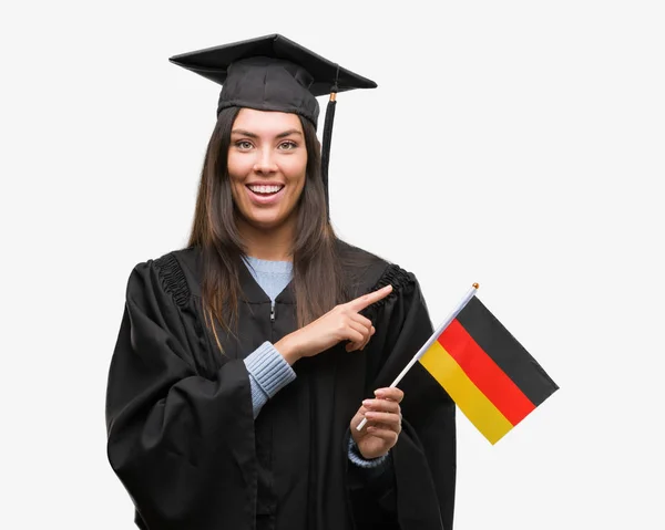 Mujer Hispana Joven Vistiendo Uniforme Graduado Sosteniendo Bandera Alemania Muy —  Fotos de Stock