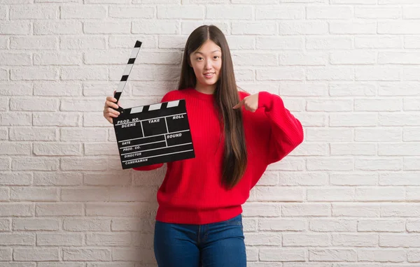 Joven Mujer China Sobre Pared Ladrillo Blanco Sosteniendo Clapboard Con — Foto de Stock