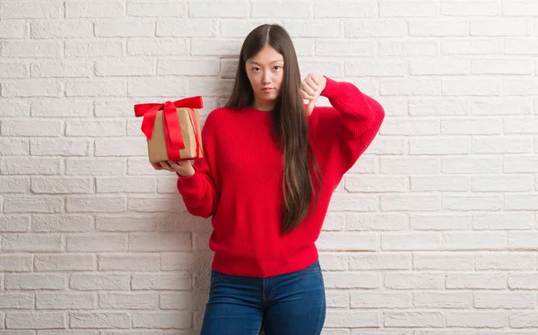 Young Chinese Woman Brick Wall Holding Gift Angry Face Negative — Stock Photo, Image