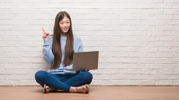 Joven Mujer China Sentada Suelo Sobre Pared Ladrillo Usando Ordenador —  Fotos de Stock