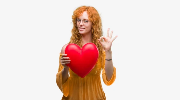Молода Руда Жінка Любові Тримає Червоне Серце Роблячи Знак Пальцями — стокове фото