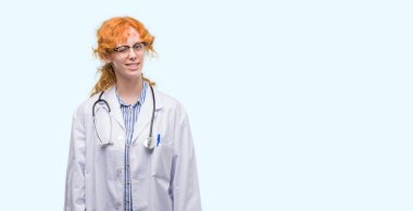 Seksi bir ifadeyle, neşeli ve mutlu yüzünü kameraya bakarak Doktor üniforma göz kırpıyor giyen genç Kızıl saçlı kadın.