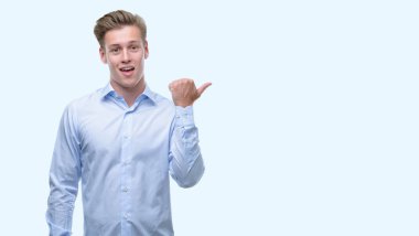 Genç yakışıklı sarışın adam el ve parmak ile yukarı dönük mutlu yüz gülümseyen ile