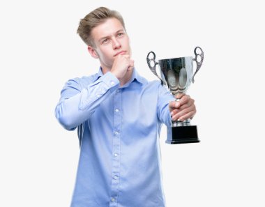 Genç yakışıklı sarışın adam soru çok karışık fikir hakkında düşünme bir kupa ciddi bir yüz tutan