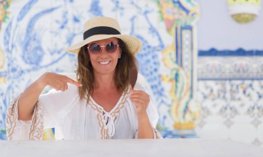 Orta yaş esmer kadın kendisine sürpriz yüz işaret parmağı ile dondurma yeme